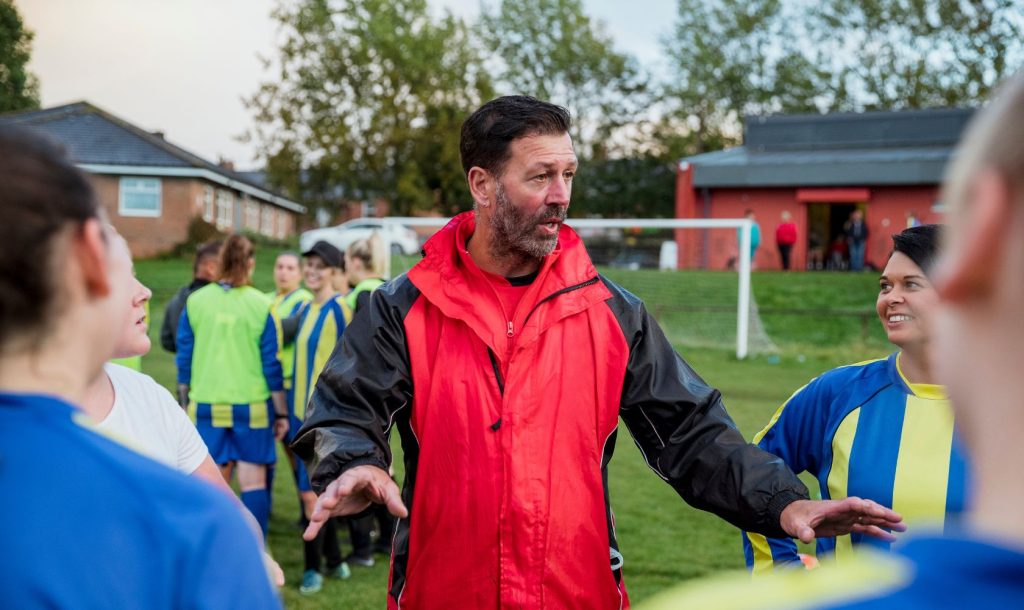 Coach speaking with his football players