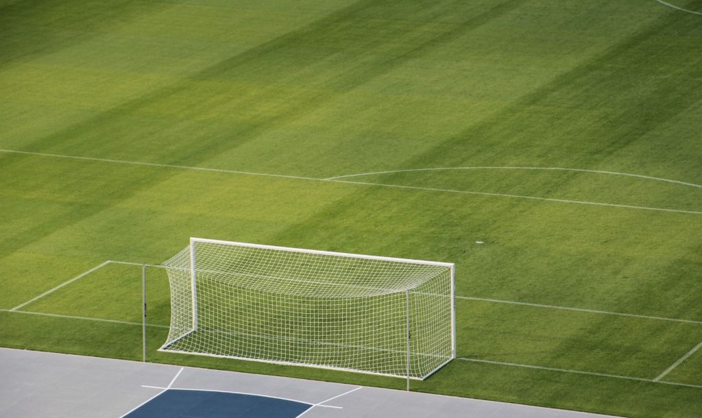 An aerial view of a goal on a pristine stadium soccer field.