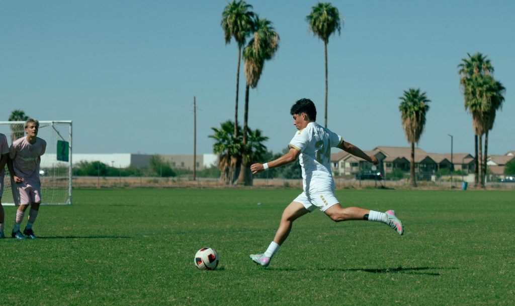 A football player takes a free kick.