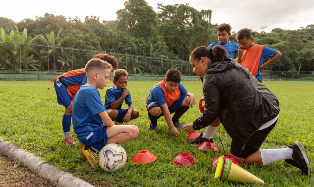 Soccer coach speaks to a group of players.